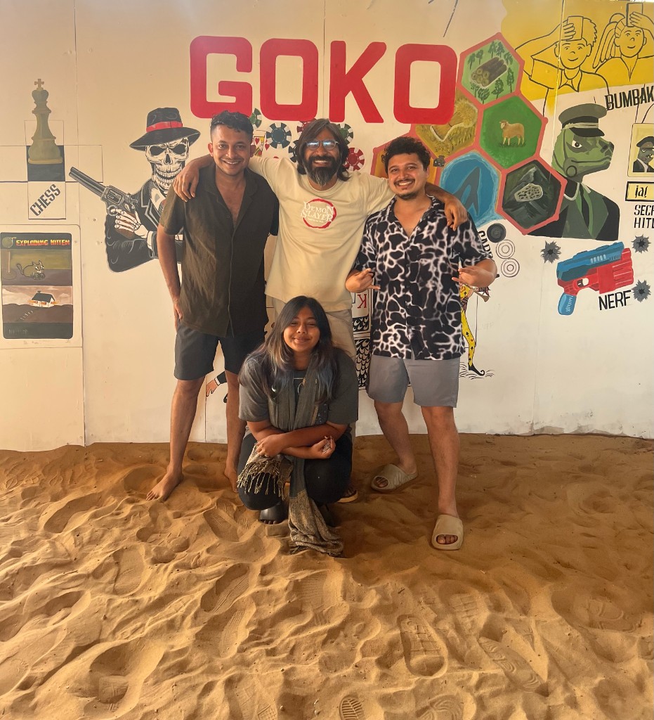 Goko founders and team in front of the GOKO games mural on the sand